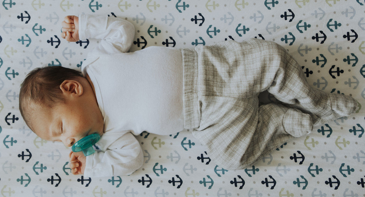 baby sleeping in crib with pacifier