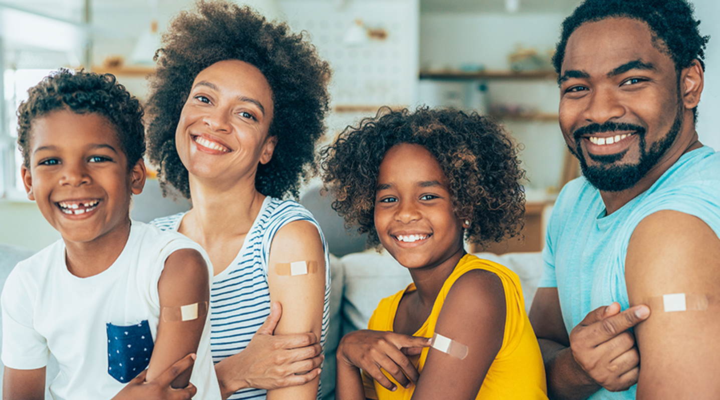 family of four with immunization bandages on arms