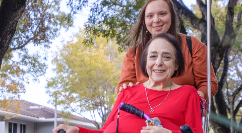 Jan, being pushed in her wheelchair by her daughter