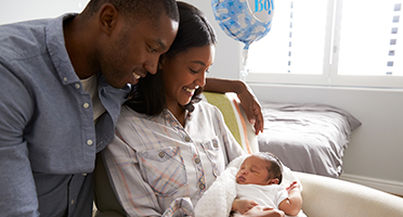 parents smiling at newborn