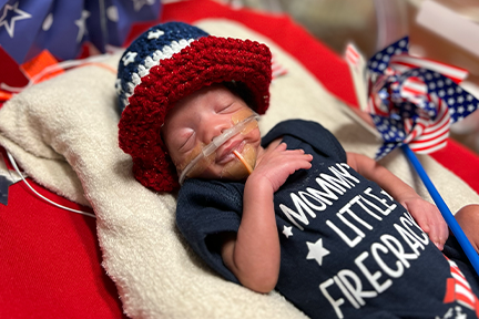 NICU baby in navy onesie July 4