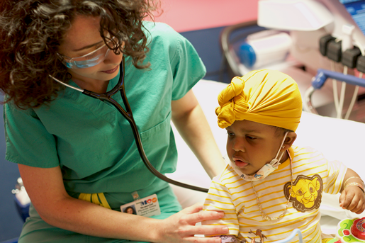 Pediatric ER doctor with patient, perming an examination