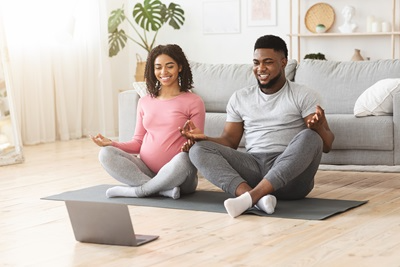 pregnant couple doing virtual yoga