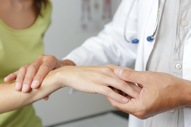 doctor examining patient's hand and wrist