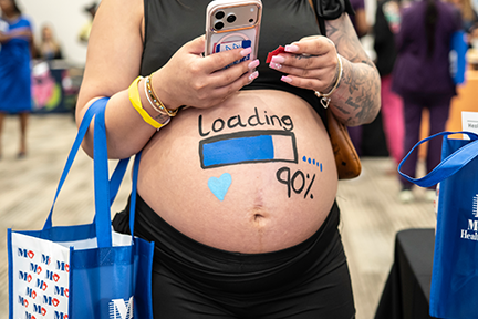 Loading 90% painted on pregnant person's belly